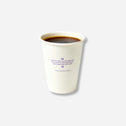 A white paper cup filled with hot coffee, showing a small printed quote about sloth welfare with “Source: The Sloth Institute” beneath it.