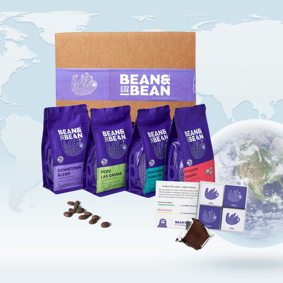 A Bean & Bean gift set featuring a branded shipping box, four purple bags of coffee with different labels, a coffee-and-chocolate pairing card, and assorted chocolate squares, shown on a light world map background with a small globe in the corner.