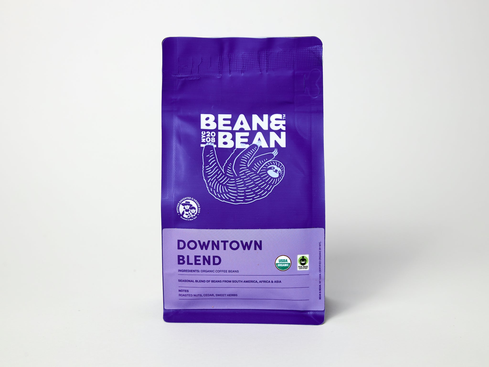 Purple "Bean & Bean Coffee Roasters" bag with a colored label that says Downtown Blend, Organic & Fair Trade