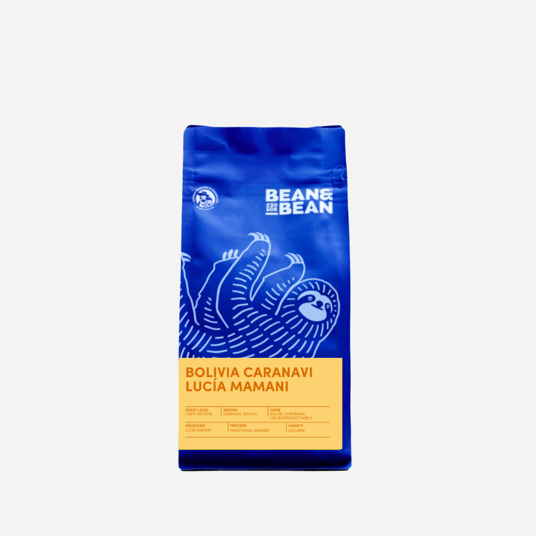 Purple &quot;Bean &amp; Bean Coffee Roasters&quot; bag with a colored label that says Bolivia Lucia Mamani