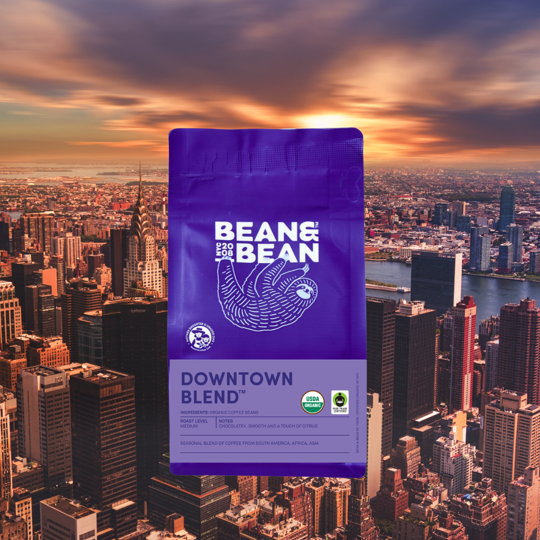 Purple Bean & Bean “Downtown Blend” coffee bag centered over a sunset skyline of New York City.