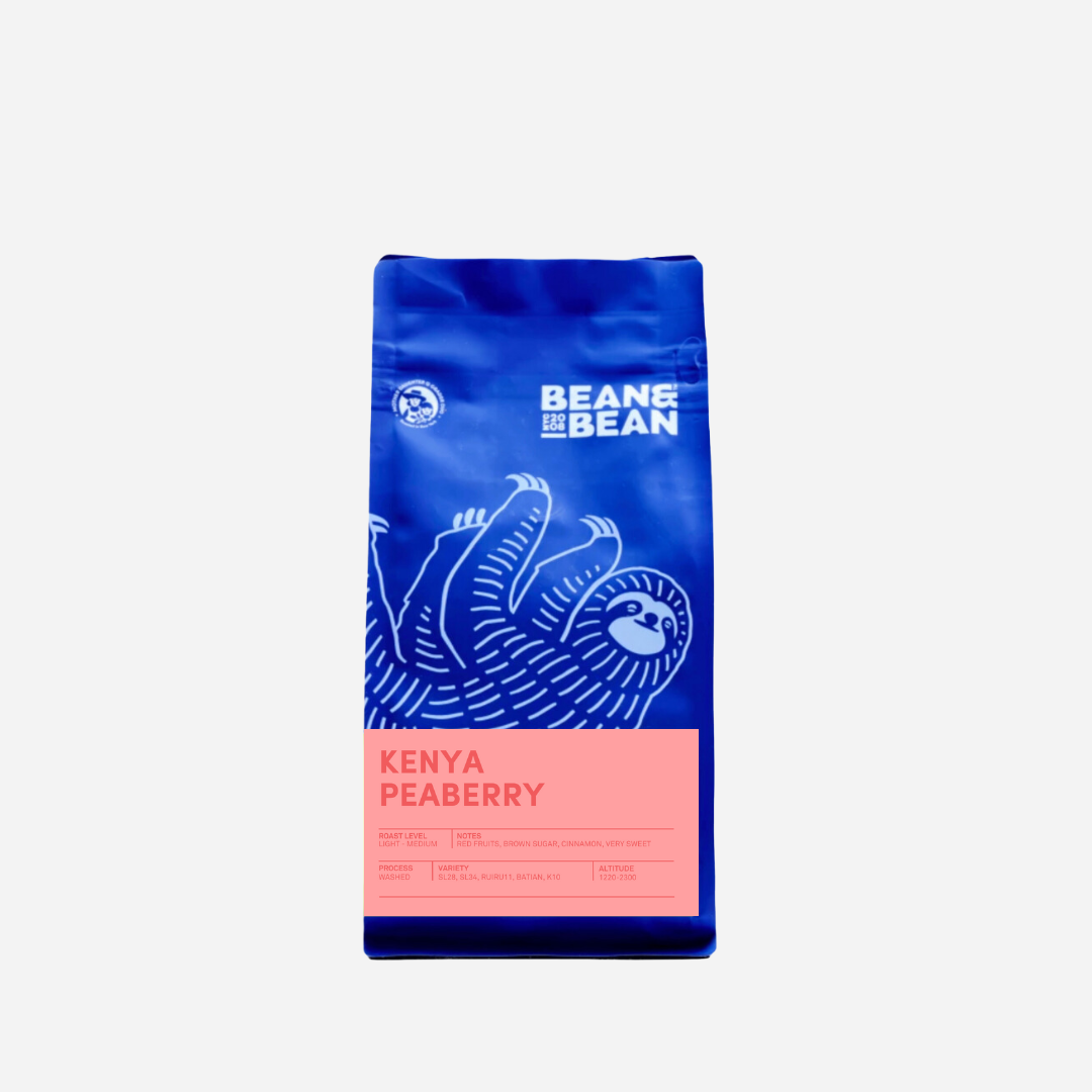 Purple "Bean & Bean Coffee Roasters" bag with a colored label that says Kenya Peaberry