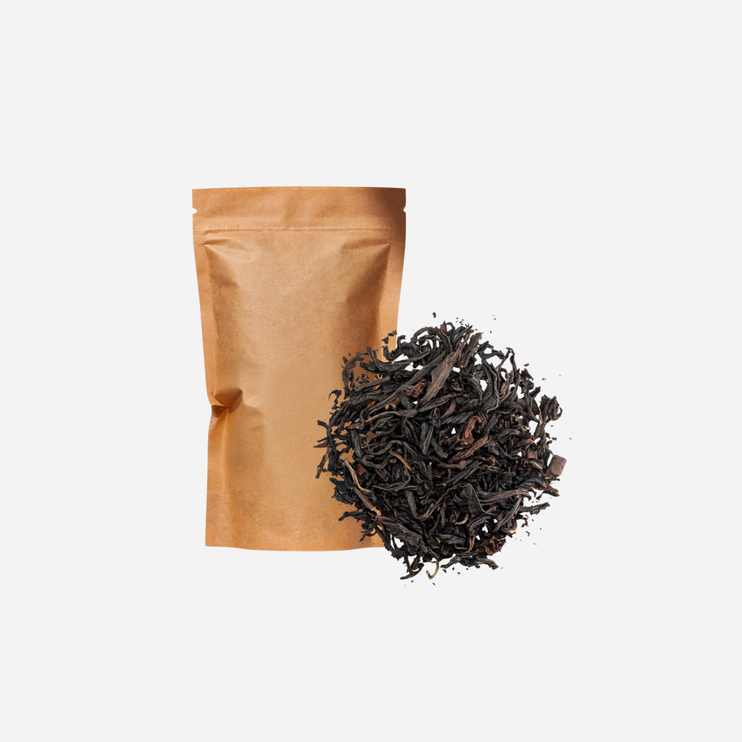 A plain brown kraft pouch shown with loose leaf black tea.