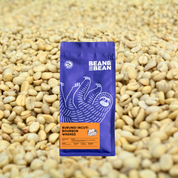 A Bean & Bean bag of Burundi Incuti Bourbon Washed against a background of dried coffee beans.