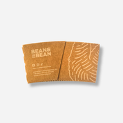 A brown craft sleeve with the “BEAN & BEAN” logo, small social media icons, and location/website text on the left, plus a light pattern graphic on the right.