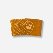 A brown craft coffee sleeve with a light sloth illustration wrapping around the left side.
