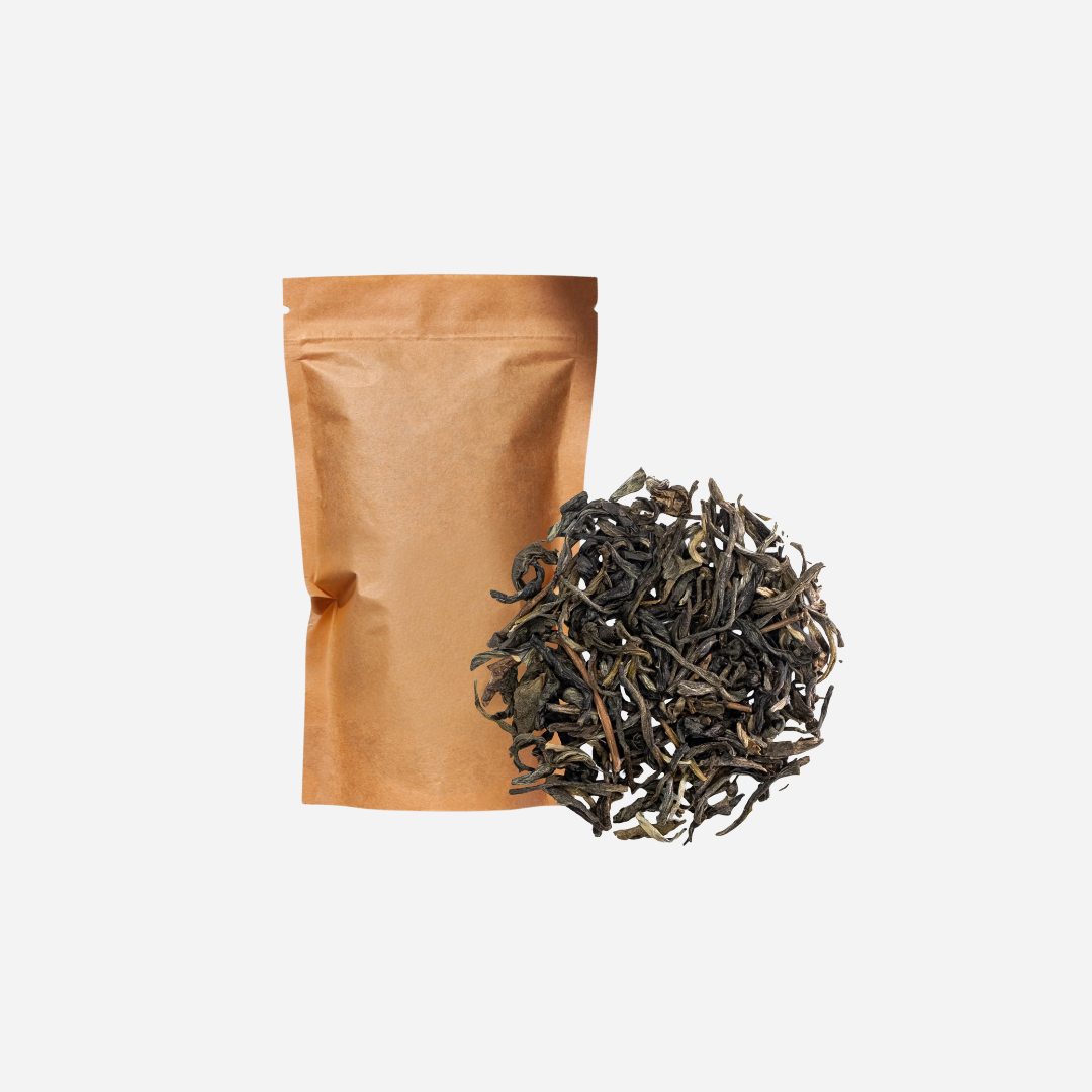 A plain brown kraft pouch shown with loose leaf greeen tea.