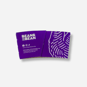 A purple coffee sleeve with the “BEAN & BEAN” logo, social media icons, and small address/website text in white, with a white pattern graphic on the right.
