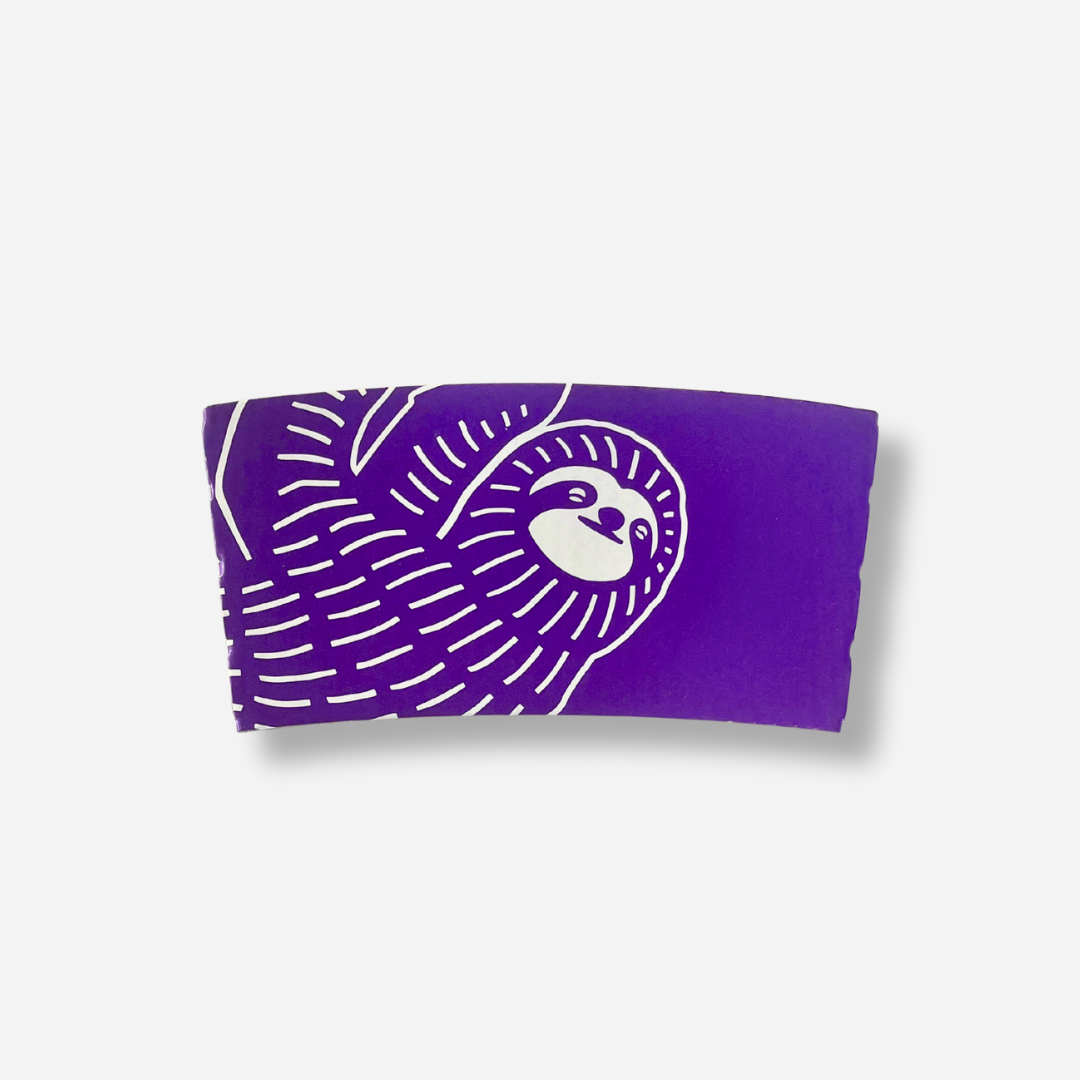 A purple coffee sleeve featuring a large white sloth illustration across the sleeve.